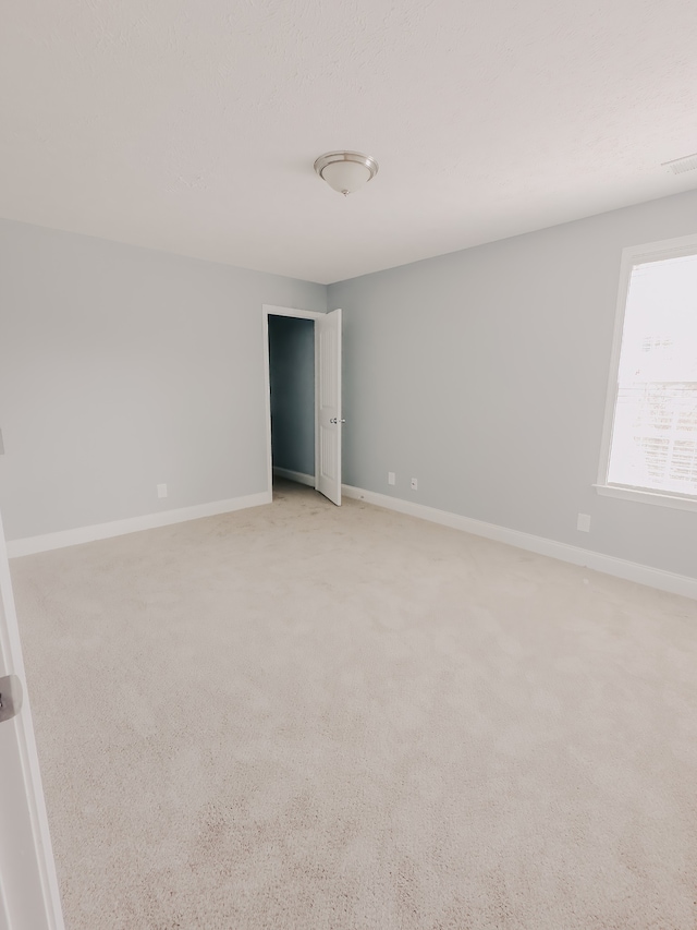 unfurnished room featuring light colored carpet