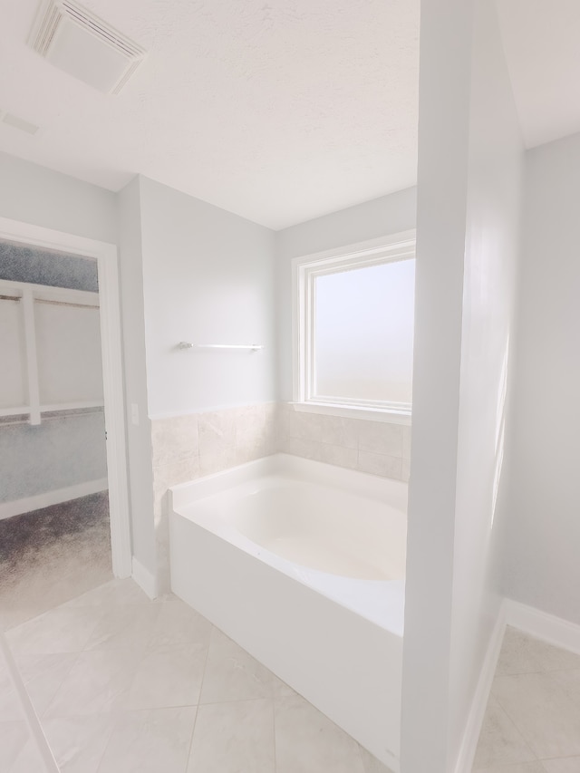 bathroom featuring tile patterned flooring and a washtub