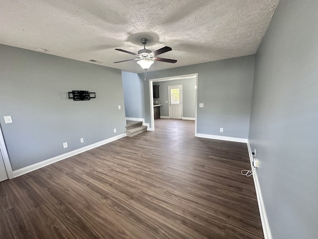 spare room featuring dark wood-type flooring, a textured ceiling, and ceiling fan