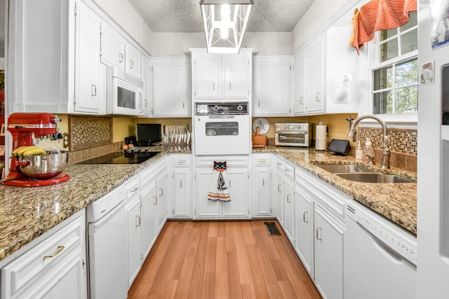 kitchen featuring white cabinets, white appliances, and sink