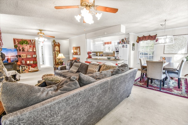 living room with ceiling fan, sink, a textured ceiling, and light carpet