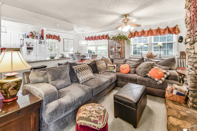 carpeted living room featuring a textured ceiling and ceiling fan