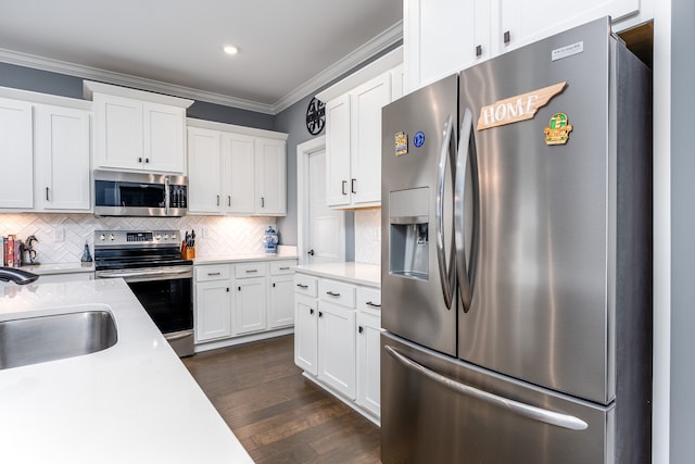 kitchen featuring white cabinetry, stainless steel appliances, crown molding, and dark hardwood / wood-style flooring