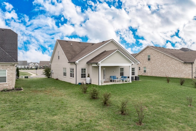 back of property featuring a yard, outdoor lounge area, central AC, and a patio area