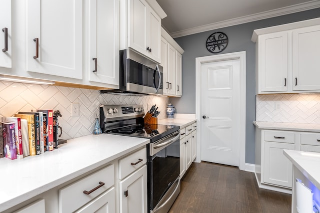 kitchen with white cabinets, stainless steel appliances, ornamental molding, and dark hardwood / wood-style floors