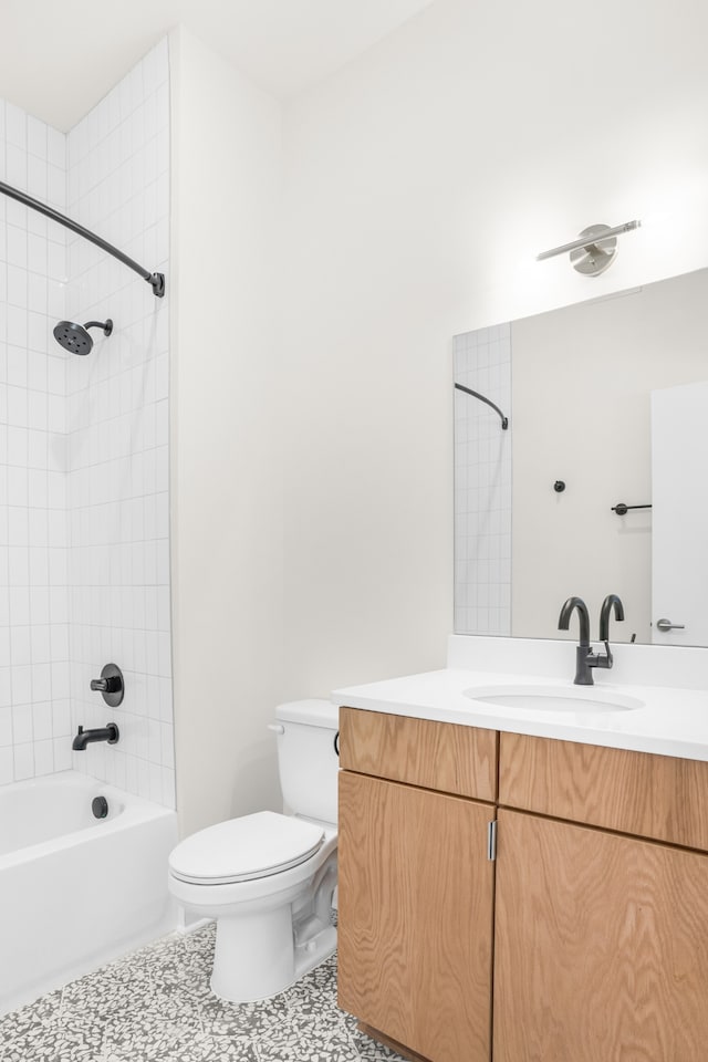 full bathroom with tiled shower / bath combo, vanity, tile patterned floors, and toilet