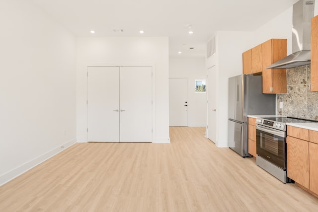 kitchen featuring light hardwood / wood-style flooring, tasteful backsplash, wall chimney exhaust hood, and stainless steel appliances