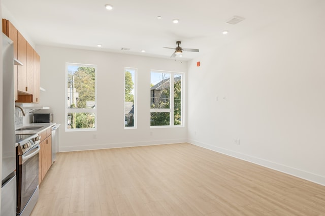 kitchen with stainless steel appliances, ceiling fan, sink, and light wood-type flooring