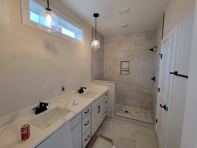 bathroom with tiled shower and vanity