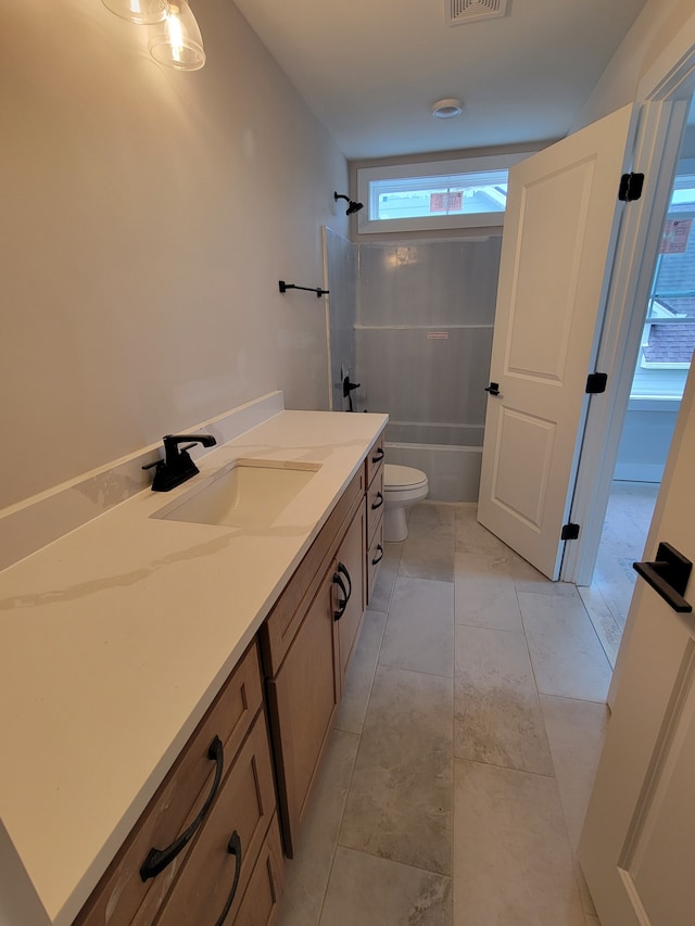 full bathroom with toilet, vanity, tiled shower / bath, and tile patterned flooring