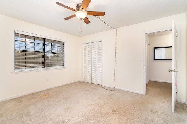 unfurnished bedroom featuring a closet, light colored carpet, and ceiling fan