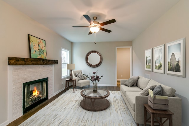 living room featuring ceiling fan, dark wood-type flooring, and a fireplace