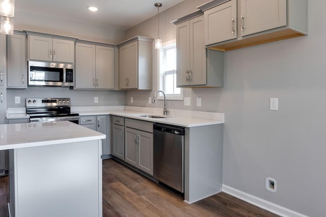 kitchen with stainless steel appliances, gray cabinetry, dark hardwood / wood-style floors, decorative light fixtures, and sink