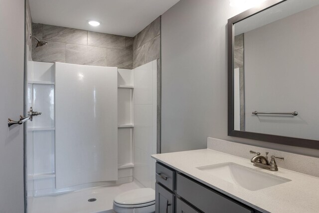 bathroom with a shower, toilet, and vanity