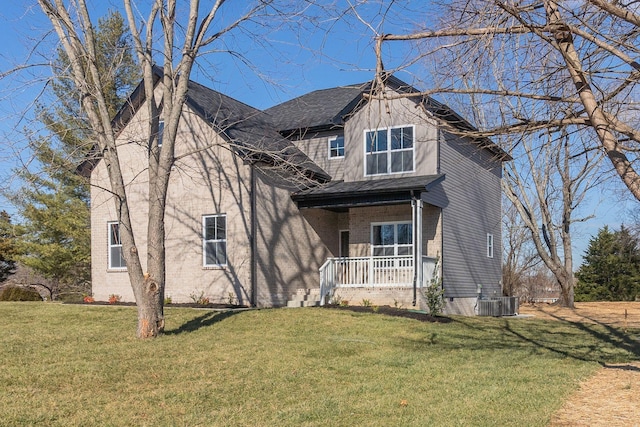 view of front of home with covered porch, cooling unit, and a front lawn