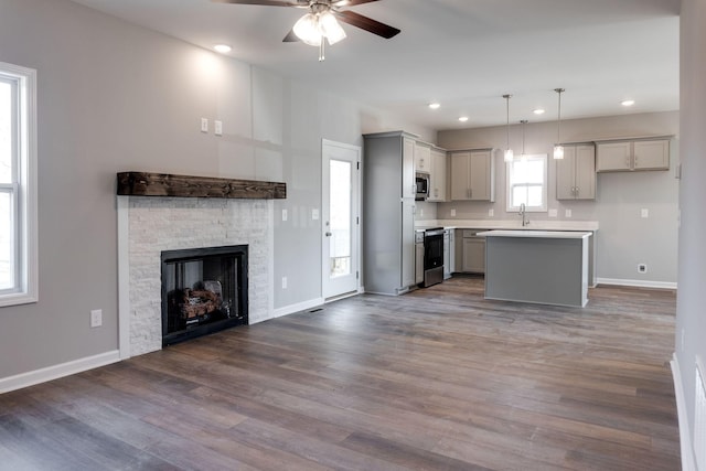 kitchen with pendant lighting, a kitchen island, stainless steel appliances, ceiling fan, and gray cabinetry