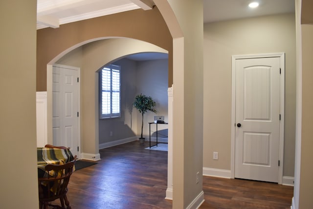 entryway with beamed ceiling, dark hardwood / wood-style floors, and crown molding