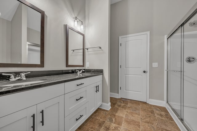 bathroom with vanity and a shower with door