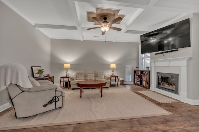 living room featuring hardwood / wood-style floors, coffered ceiling, beamed ceiling, ceiling fan, and crown molding