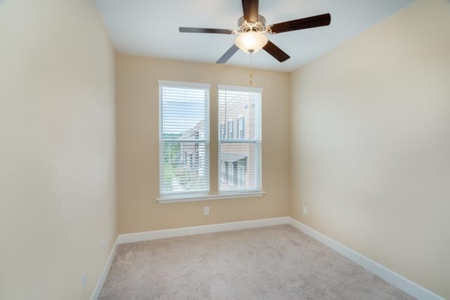 carpeted spare room featuring ceiling fan