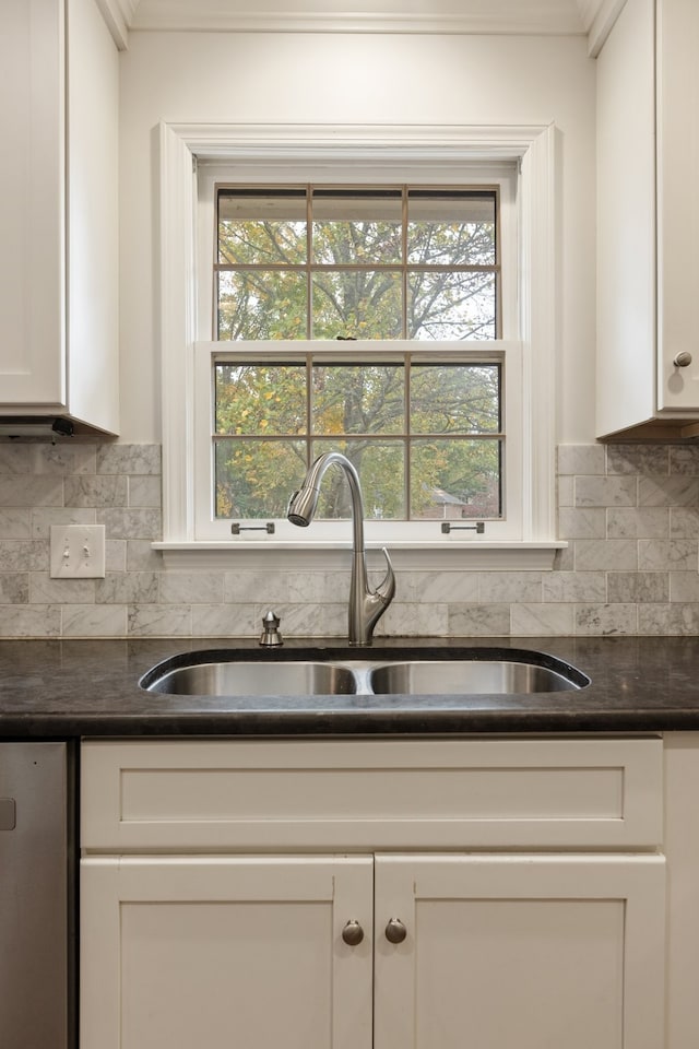 kitchen featuring plenty of natural light, white cabinetry, sink, and tasteful backsplash