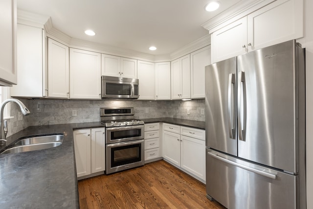 kitchen featuring white cabinetry, sink, appliances with stainless steel finishes, backsplash, and dark wood-type flooring