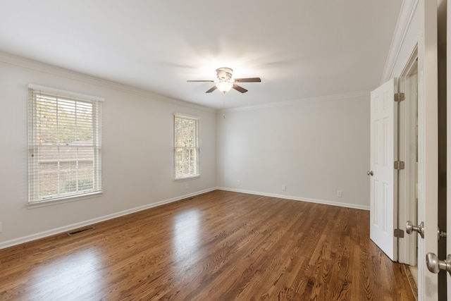 spare room featuring dark hardwood / wood-style floors, plenty of natural light, and crown molding