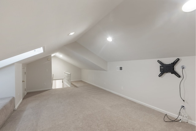 additional living space featuring light carpet and vaulted ceiling