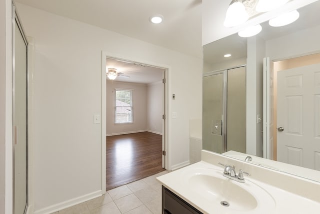 bathroom featuring vanity, wood-type flooring, ceiling fan, and a shower with shower door