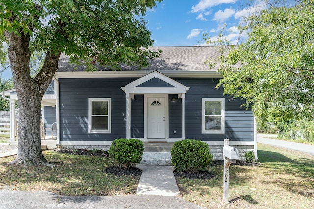 bungalow-style home with a front lawn