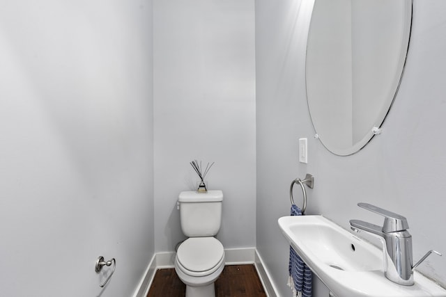 bathroom featuring hardwood / wood-style flooring, toilet, and sink