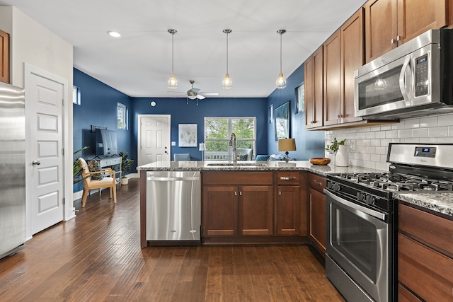 kitchen with kitchen peninsula, stainless steel appliances, sink, and dark hardwood / wood-style floors