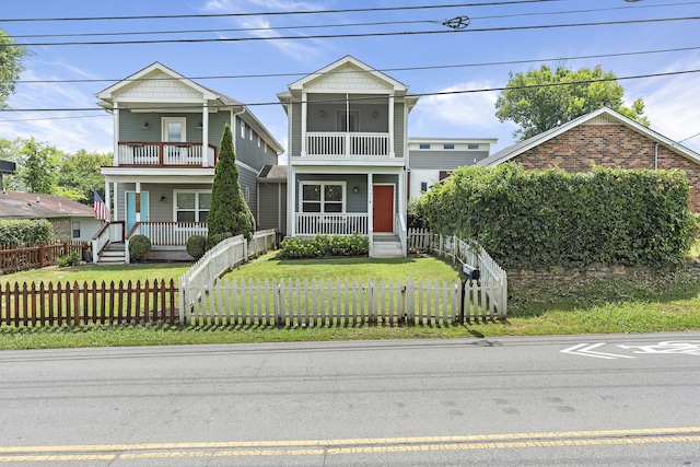 view of front of home with a front yard, covered porch, and a balcony