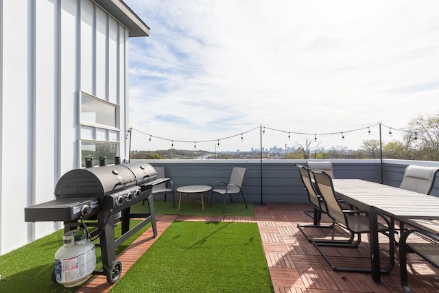 wooden terrace featuring area for grilling and a yard