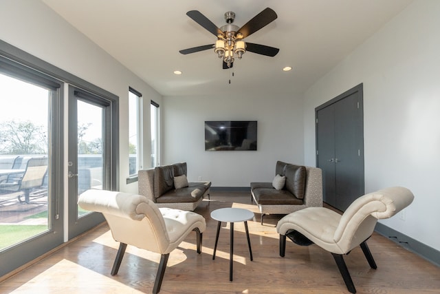 living room featuring ceiling fan, light hardwood / wood-style floors, and plenty of natural light