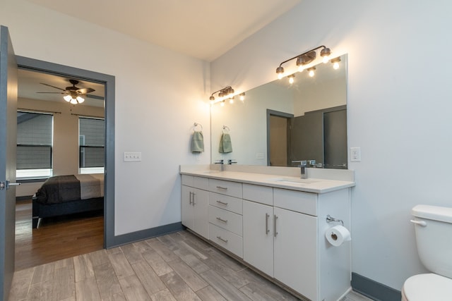 bathroom featuring hardwood / wood-style floors, vanity, ceiling fan, and toilet