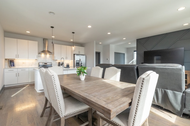 dining area with light wood-type flooring and sink