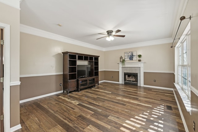 unfurnished living room featuring ceiling fan, a fireplace, dark wood-type flooring, and ornamental molding