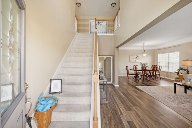 staircase with crown molding and hardwood / wood-style floors