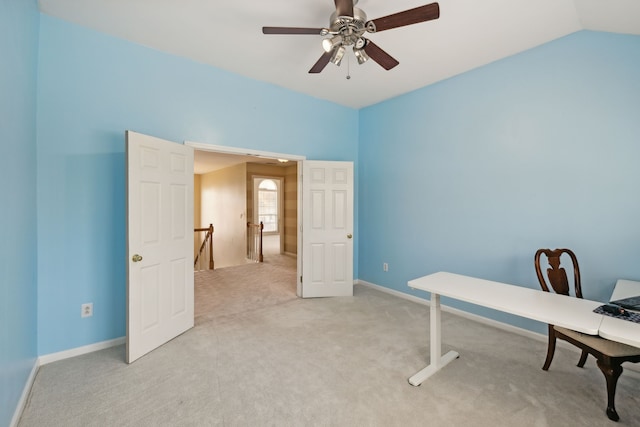 carpeted home office with ceiling fan and vaulted ceiling