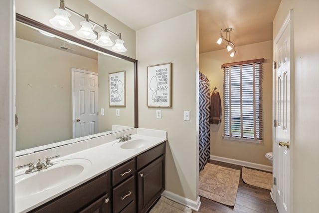 bathroom with hardwood / wood-style floors, vanity, and toilet