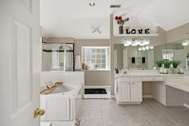 bathroom featuring tile patterned flooring, vanity, a healthy amount of sunlight, and vaulted ceiling