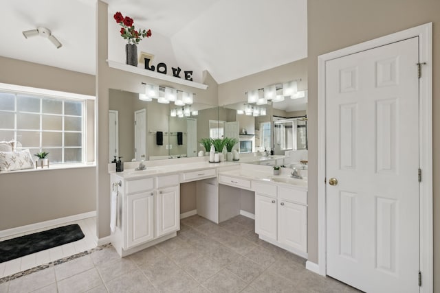 bathroom with tile patterned floors, vanity, and vaulted ceiling