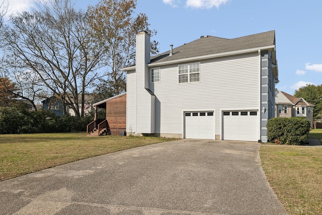 view of side of home featuring a garage and a lawn