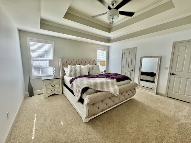 bedroom with multiple windows, light carpet, and a raised ceiling