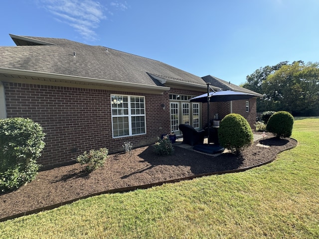 back of house featuring french doors, a lawn, and a patio