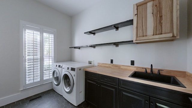 washroom with cabinets, washer and clothes dryer, sink, and dark tile patterned floors