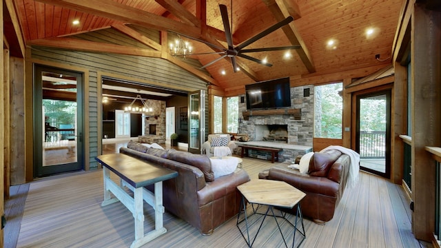 living room featuring wooden ceiling, a fireplace, a notable chandelier, wooden walls, and light wood-type flooring