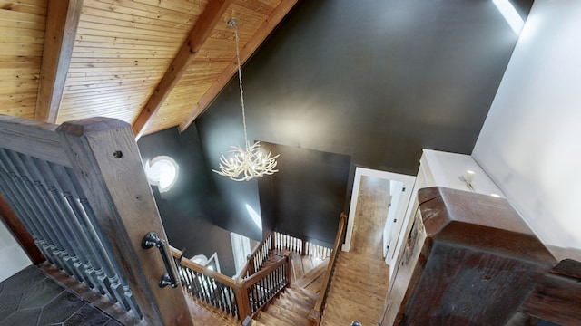 stairway featuring a notable chandelier, high vaulted ceiling, hardwood / wood-style flooring, beamed ceiling, and wooden ceiling