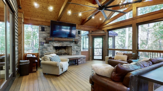 living room with a stone fireplace, light wood-type flooring, plenty of natural light, and wood ceiling